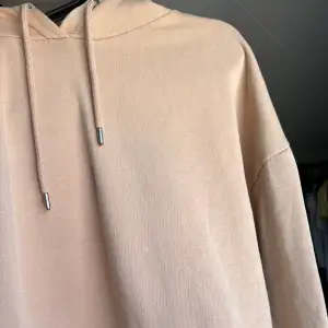 En beige hoodie ifrån nly trend i storlek S. Modellen är oversized.  