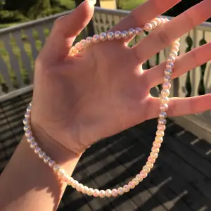Vackert pärlhalsband gjort av vita och rosa pärlor. Handgjort och nytt. Kontakta gärna vid frågor, köpare står för frakt.  Har också andra smycken på min profil.