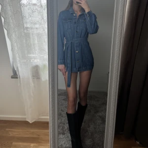 Jeansklänning - Helt ny, jätte fin jeansklänning från Boohoo ✨  Storlek 36. Säljer då den är för liten för mig (är 179cm lång) så den är normal i storlek. Säljer även bootsen på bilden 