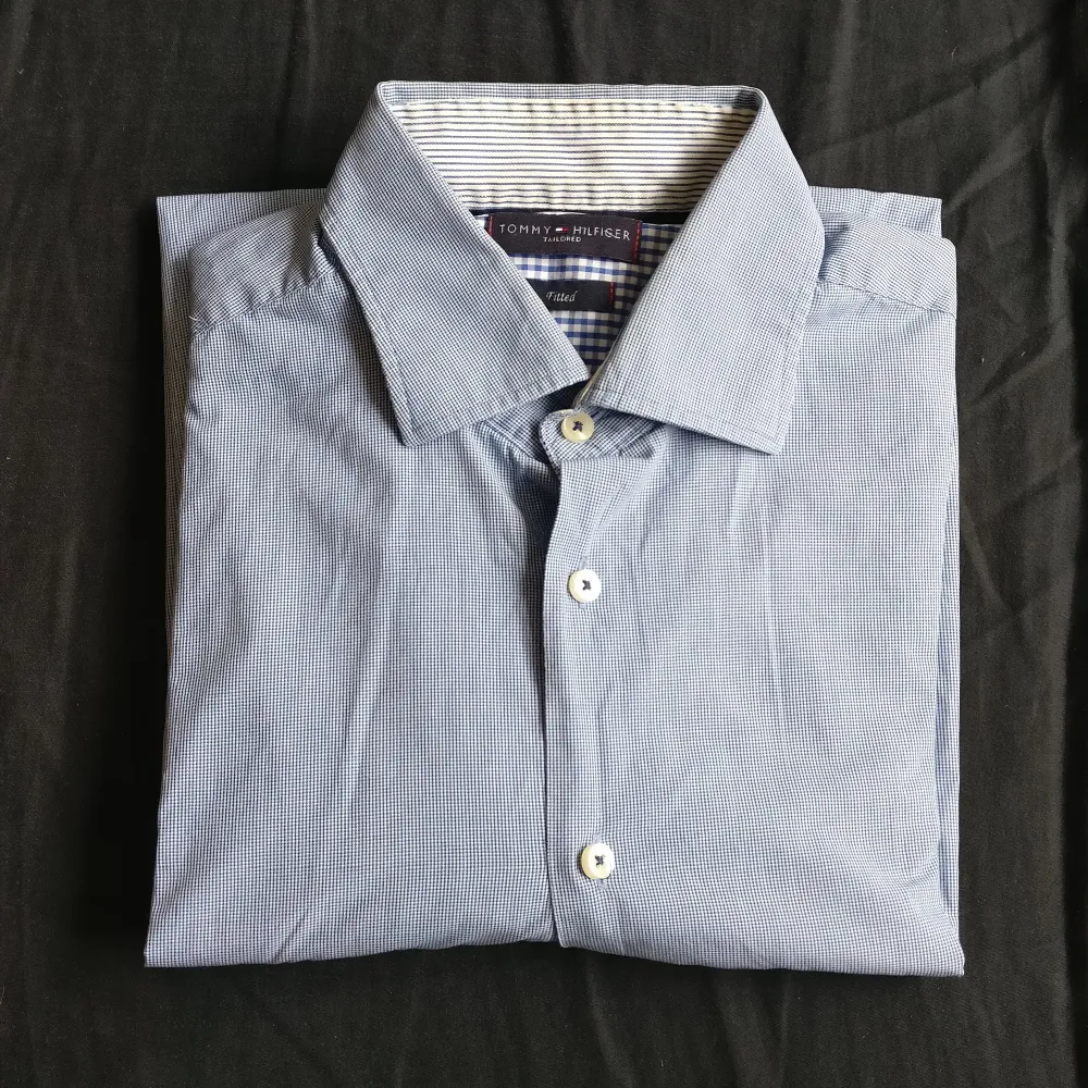 Skjorta från Tommy Hilfiger i bra skick. Ljusblå med smårutigt mönster. Bra finskjorta eller jobbskjorta. Köparen står för frakt.. Skjortor.