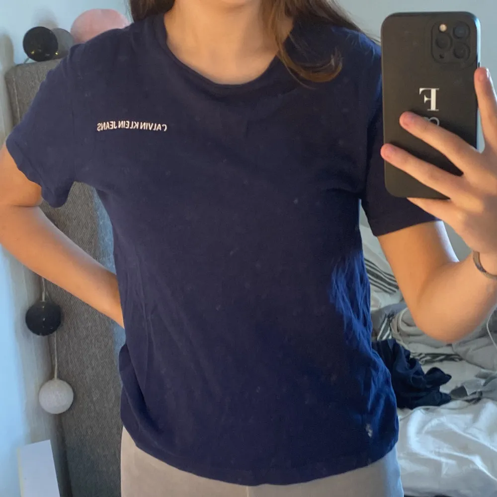 En mörkblå Calvin Klein t-shirt i storlek 152 men sitter som en XS på mig. Ganska använd och är i hyfsat skick, det ända som är lite slitet är trycket på vänster sida.💕. T-paidat.