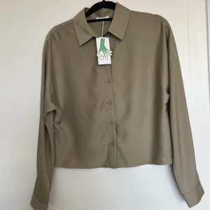 Boxig skjorta  - Härlig skjorta ifrån Wera i storlek 34. Skjortan är i en boxig och något croppad modell. Plagget är i väldigt fint skick då det endast är testat, prislapp kvar! Säljes på grund av fel storlek.  