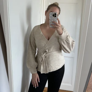 Omlott-tröja - Fin, stickad omlott-tröja från Asos. Köpt förra året och använt endast några gånger. Justerbar med bandet runtom. 