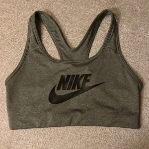 Nike sport-bh - En sport-bh från Nike i en lite gråmelerad färg och svart tryck, strl s