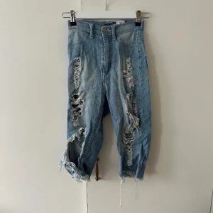 Ripped denim shorts  - Goes below the knees 