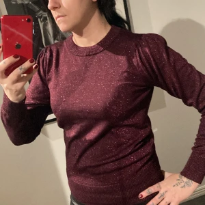 Glittrig långärmad tröja - Jättefin tröja, vinröd och glittrig med lite lite puff vid axlarna.  Använd en gång och tvättad, så den är i nyskick.  Jag på bilden har strl s-m