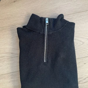 Svart Halvzip - Säljer denna stilrena halvzip ifrån HM i storlek s.