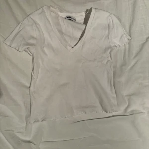 Vit t-shirt - T-shirt med söta detaljer på ärmarna och v-ringning. Storlek xxs men passar även mig som har S då den är stretchig.