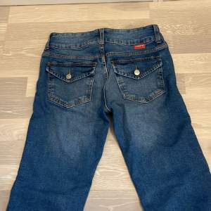 Snygga lågmidjade jeans med fina fickor på baksidan.  Jeans med två knappar 