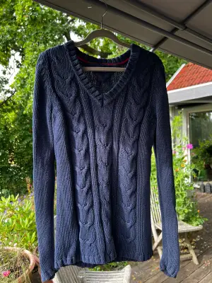En mörk blå kabelstickad tröja från Tommy Hilfiger i storlek S