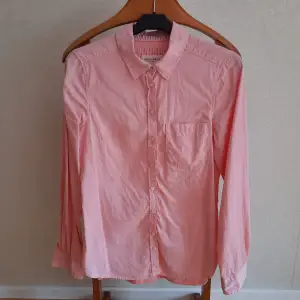 Ny skjorta från Lindex. Ljusrosa. 100% bomull.  Mått: längd (rygg) 67,5 cm, omkrets (under ärmarna) 90 cm.