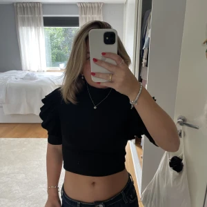 Stickad kortare topp - Stickad kortare tröja den zara med volanger vid ärmarna och en högre krage. Jättefin nu till hösten, köpt för ca 1,5 år sedan men kommer tyvärr inte till användning, bra skick använd en gång, skriv vid frågor ❤️