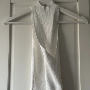 Vit top, ribbad, Gina Tricot med ”twist” framtill - syns ej bra på bild men halslinningen har en ”twist”. I princip oanvänd.
