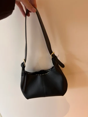 Svart väska  - Svart väska med guld detaljer. Knappt använda så fint skick.