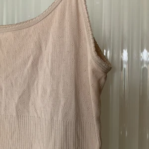 Linne från Noa Noa - Supergulligt beiget linne från Noa Noa med fina detaljer och justerbara band. Storlek L men skulle säga att det funkar även på S/M. 