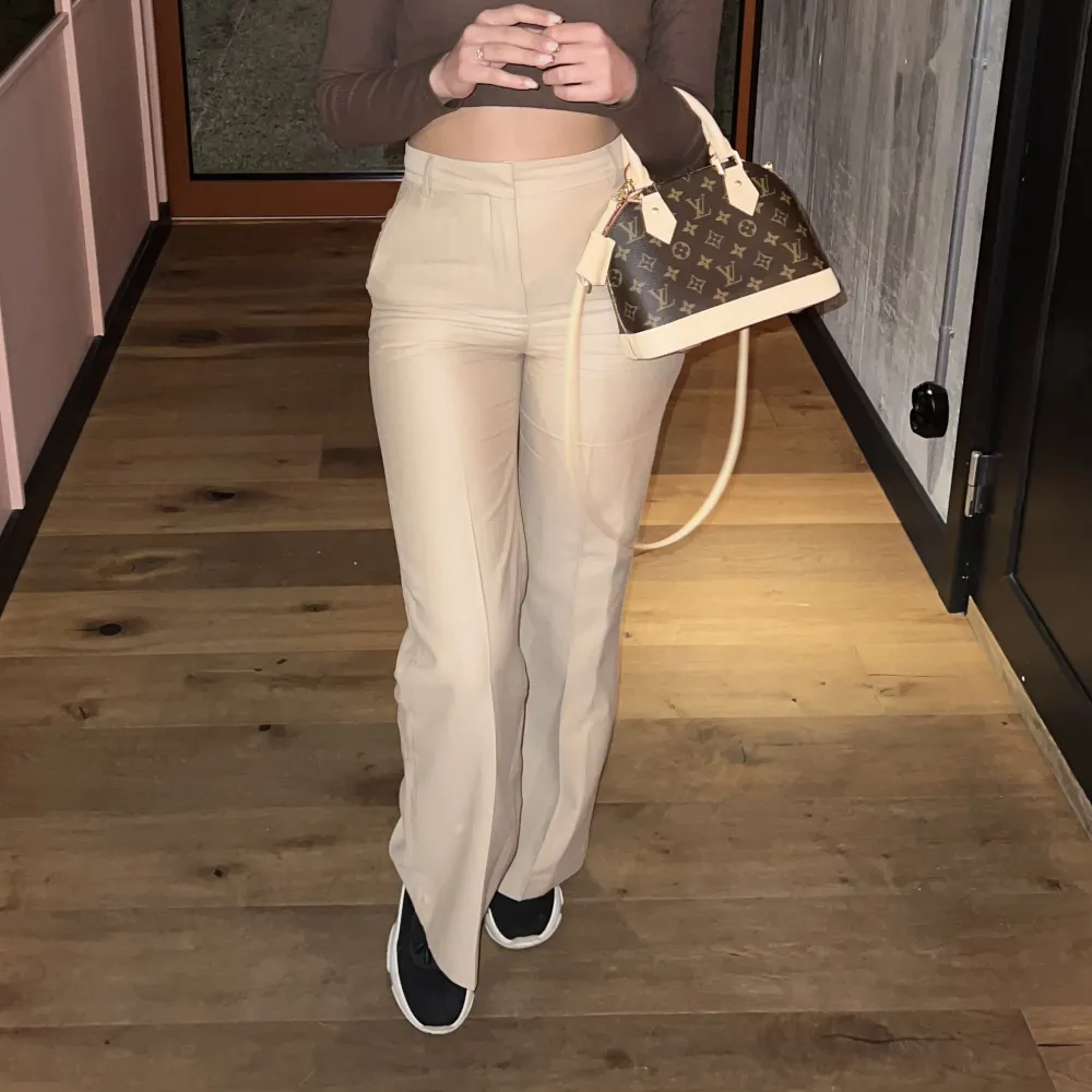 Ett par beigefärgade kostymbyxor köpt från hmtrend. De har en flared modell.Jätte fin kvalite i en lyocell blandning. Sälje dom tyvärr för att dom blivit små på mig. Använd fåtals gånger men fortfarande i gott skick. Färgen är som bilden från hms hemsida.. Farkut & Housut.