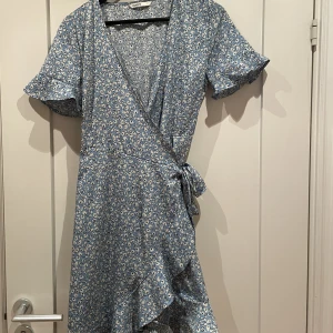 Blommig omlottklänning - Blommig omlottklänning från ONLY,  storlek 38, använd fåtal gånger 