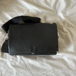 Svart Axelremsväska  - Jättefin axelremsväska, säljer för att den inte kommer till användning 