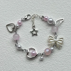 rosa armband  - handgjort armband med vita och rosa pärlor samt berlocker 🎀 justerbar passform, se mått på bild 2. bra skick, säljer liknande smycken på min profil! skriv gärna vid funderingar 💕 (frakt: 15kr, skickas som brev)
