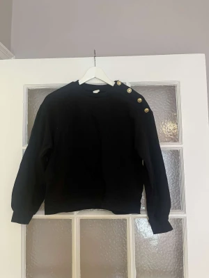 Fin tröja - Fin tröja från H&M med guldknappar vid ena axeln. Sparsamt använd. 