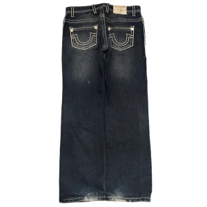 Joey super T baggy trues - Baggy jeans från True religion i modellen Joey super T. Benöppning 22cm!! Storlek 38x34.