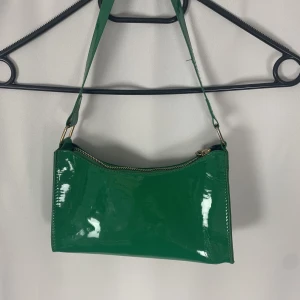 Axelväska - Grön axelväska med ett fack och guldiga detaljer