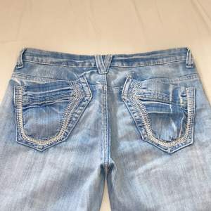 💗Köp nu funktionen, först till kvarn, ingen budgivning💗Jätte snygga ljusa low waisted jeans med unika fickor!! köpta second hand men i jätte bra skick! midjemått rakt över 38cm, innerbenslängd 83cm💗