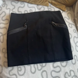 Svart kjol - Svart kjol med fake fickor  Ny skick, aldrig använd 