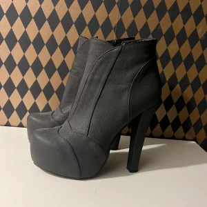 Högklackade stövletter - Snygga och fräscha stövletter från märket sugarfree shoes. Använda någon enstaka gång men i prima skick. Dom är lite gråaktiga i färgen inte svarta. 