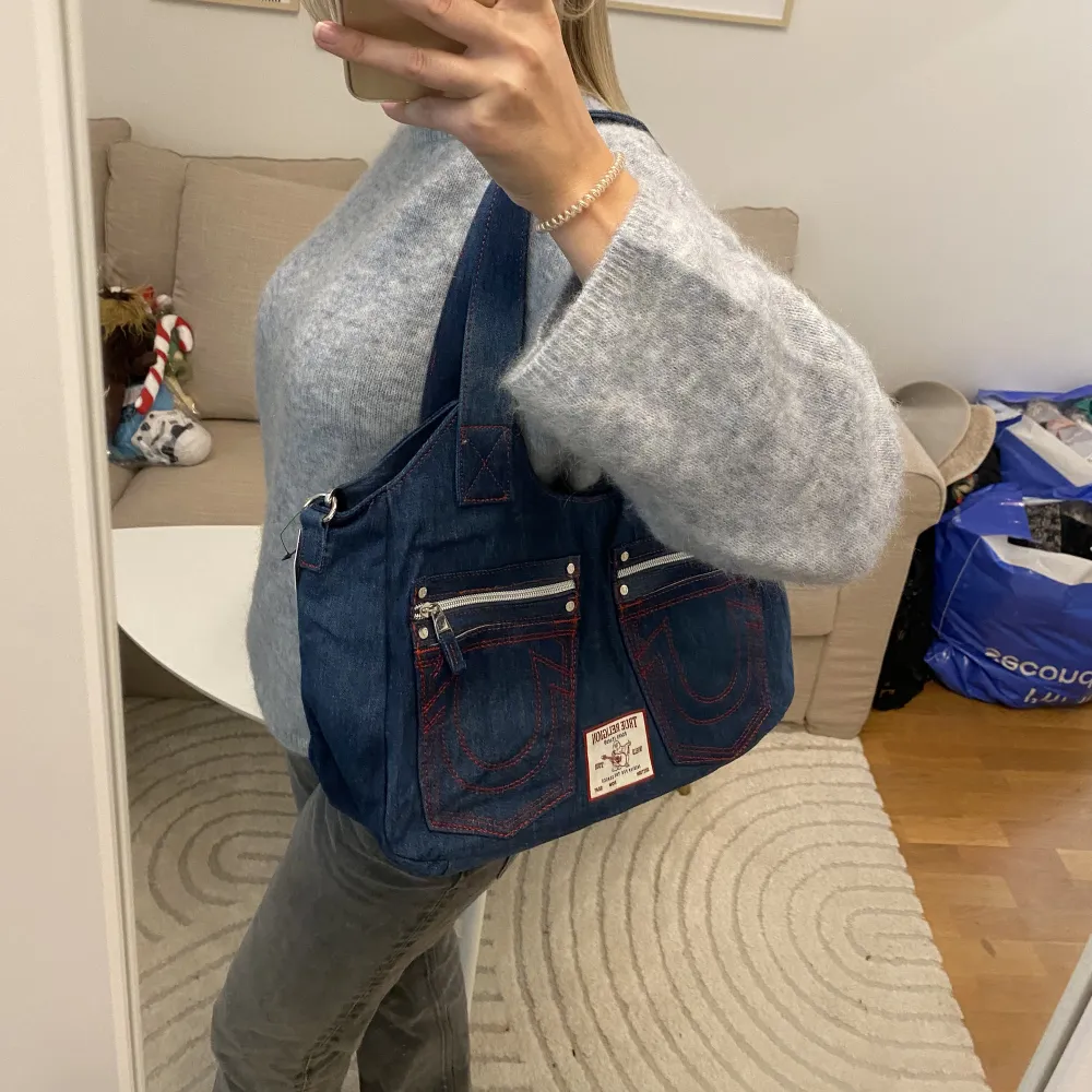 Supersnygg och cool väska från True Religion. Väskan är i jeanstyg, och är helt oanvänd med lappen kvar! Säljs pga att jag har en likadan i en annan färg! Köptes för cirka 1080kr i USA💓 (jag samfraktar!!). Väskor.