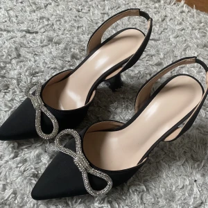 Klackskor  - Så fina klackskor med glittrig rosett🖤 Använda en gång med ser precis ut som nya!