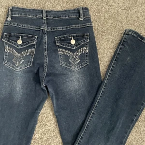 Utsvängda Jeans Med Mönster - Ett par utsvängda mörkblåa jeans med tryck där bak ifrån Shein i storlek XS. Vuxit ur dom. Frakten diskuteras privat. 