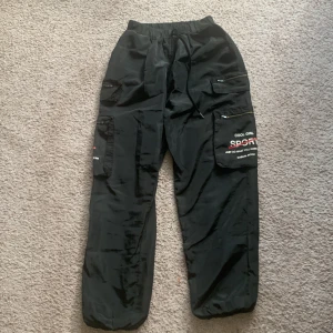 Y2k parachute byxor - Ett par snygga svarta byxor som är helt nya och använda 1 gång. Den är small vid midjan och lite stor vid benen, storlek medium. Original priset 259kr