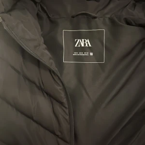 Zara väst  - En helt ny väst från zara. Köpte den  i april och har använt ca 4 gånger. Använder den inte längre. Liten fläck där vid sidan på bilden men den gick bort genom att ta bort med fingret. Övrig info: den är skön och varm. Har luva och fickor!