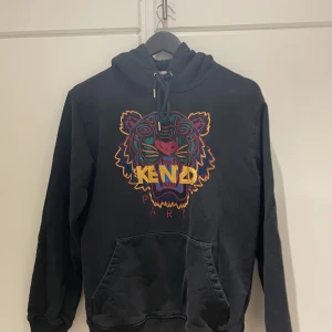 Kenzo hoddie (Herr)  - Använd få gånger inga märken på eller skador  Hör av dig vid intresse  Kenzo hoddie i fint skick använd fåtal gånger inga märken eller skador  Nypris 3000kr  Storlek: M   Betalning görs via Swish  Skickas med spårbart paket via Postnord