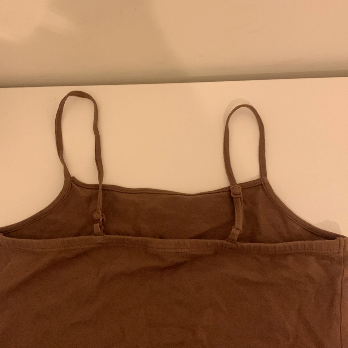 Brunt linne, inte lika lång som en t-shirt och inte som en magtröja med mittemellan. Bara använd några få gånger, jättebraskick.  - 91