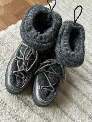 Moncler boots med grå fårull, så snygga! - Endast använda vid ett fåtal tillfälle. Så i jätte fint skick! Nypris: ca 6000:- Färg: Grå ull och grått läder Storlek: 38