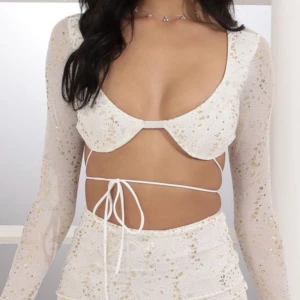 Vit festtopp - Vit topp med guldglitter och paljetter. Använd en gång. Har tappat några paljetter men inget synbart