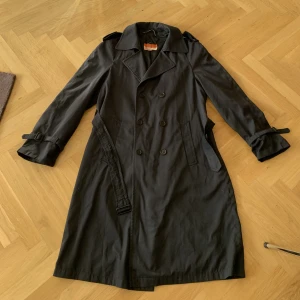 Trenchcoat  - Snygg långt vintage trenchcoat, väldigt mörkblå 💖💖 perfekt för hösten. Längd 111 cm.  Storlek uppskattas till typ L/XL, men beror ju på hur man vill att den ska sitta. Färgen är lite svår att fånga på kamera