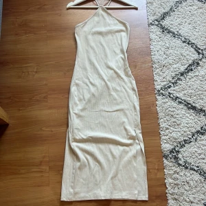 Klänning - Bommulsklänning. Lång med en slits på sidan. Korsad i ryggen. I nyskick. 