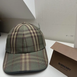 Burberry keps - Sällsynt burberry keps i mörkgrön. Cond 8/10 Strlk L(justerbart spänne) Kvitto finns. Tveka inte på att ställa frågor! Pris kan disskuteras.