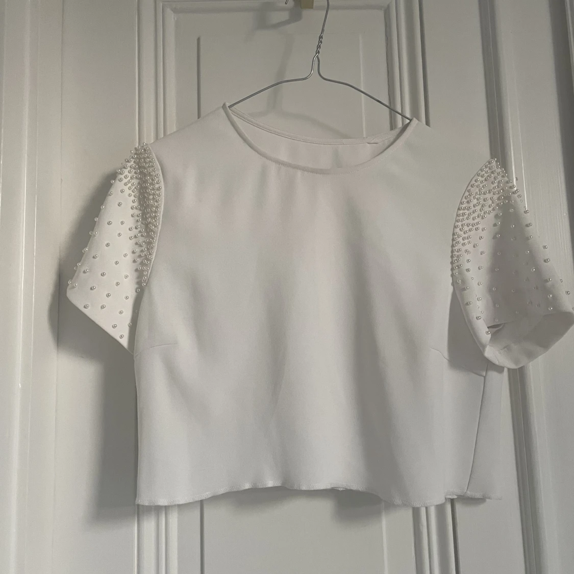Vit kort top med fina pärlor på ärmarna 