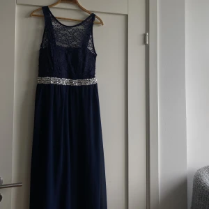 Balklänning - Suuuperfin marinblå balklänning med glittrigt ”band” runt & fin spets. Skulle säga att den passar en M-L! Passar även till finare tillställningar, mingel, bröllop etc. Inga mer defekter än att någon paljett vid bandet är lite löst, superfint skick!🫶🏼