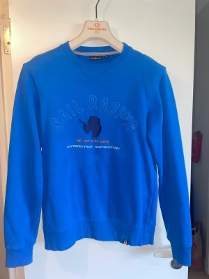 Sail Racing Sweatshirt tröja blå Antarctica Expedition blue - Sail tröja Blå tjocktröja sweatshirt   Skick: 7/10 Storlek: M  Säljs då jag tömmer garderoben och vill bli av med gamla kläder.