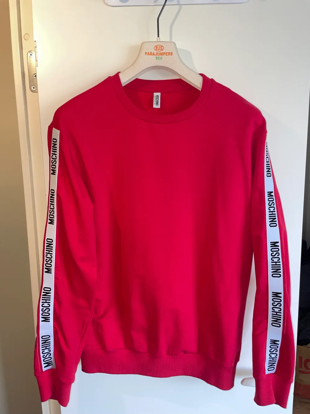 Moschino tröja i röd jättesnygg och unik  Köpt från Flannels så kvitto finns!  Skick: 9/10 Storlek: M  Säljs då jag tömmer garderoben och vill bli av med gamla kläder.. Hoodies.
