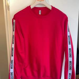 Moschino tröja i röd jättesnygg och unik  Köpt från Flannels så kvitto finns!  Skick: 9/10 Storlek: M  Säljs då jag tömmer garderoben och vill bli av med gamla kläder.
