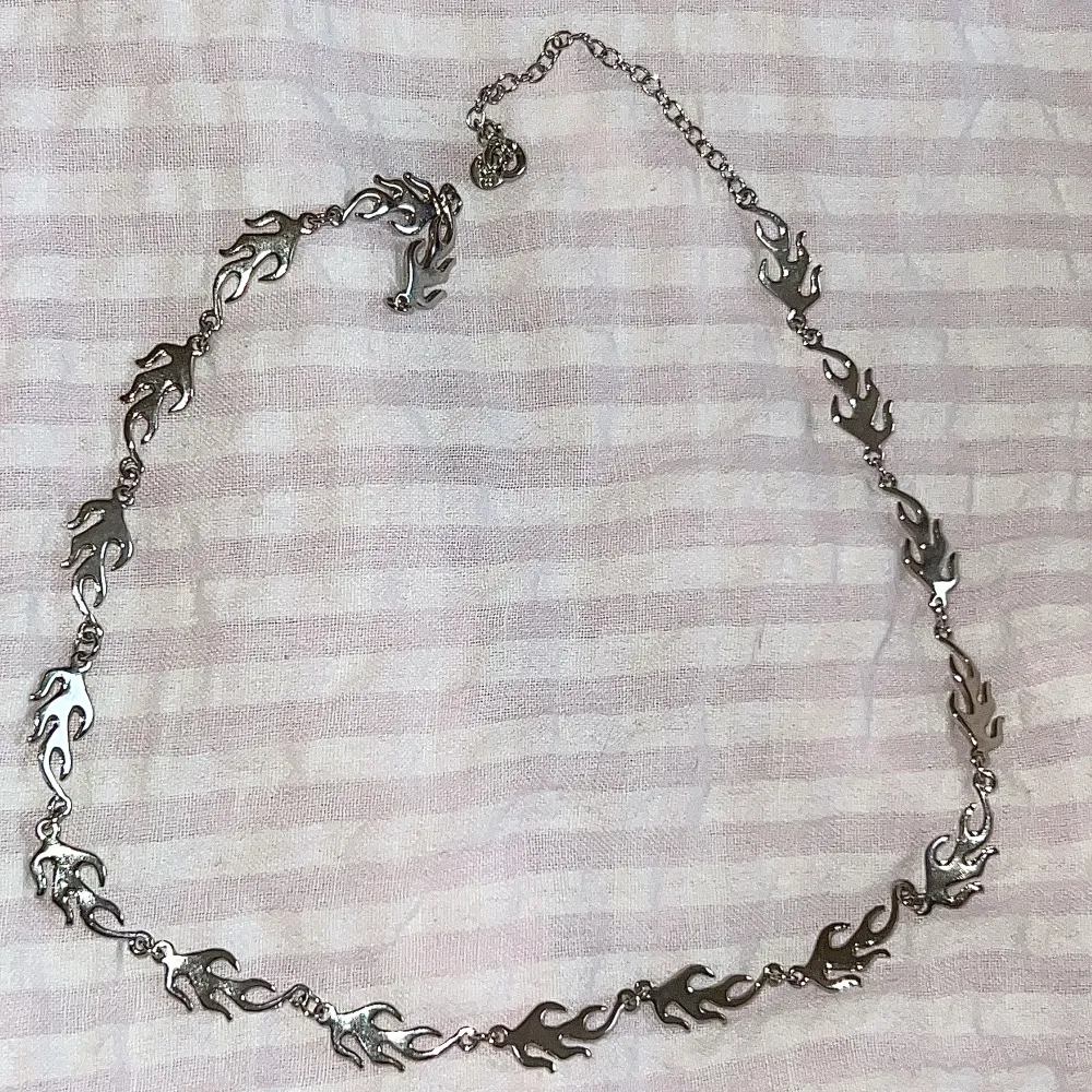 Silver halsband med eld detaljer!! Så coolt & unikt 💕 från stradivarius, är inte rostfritt men har hållt sig väldigt fint & utan defekter hitills 🤍 använd gärna köp nu✨. Accessoarer.