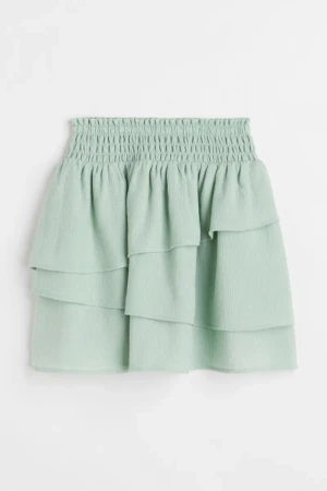 Grön Volang kjol - Säljer denna superfina gröna volang kjol köpt i Portugal förra året på hm! Ansvällde den aldrig men den sitter perfekt o inte super kort där bak❤️❤️ storlek 134/140😱 men passar mig som är xxs/ xs så aa haha