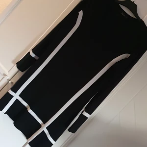 Klänning  - Klänning med lång ärm.  V-ringad i halsen.  Svart-vit.  Mjuk och skön.  Designed in Sweden. 