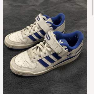 Ett par vitblåa Adidas Forum Low skor i Strl 40. Skulle även säga att skorna passar dem som bär 39 & 39.5. Har använts en sommar, men i bra skick. Säljs på grund av att dem inte riktigt är i min stil längre. Säljs för 700 SEK, men pris kan diskuteras. 